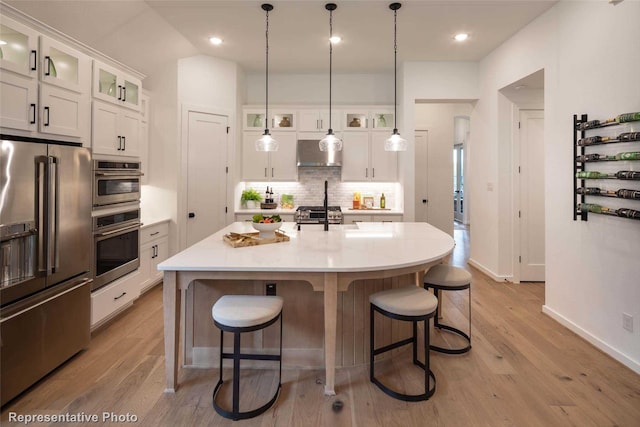 8413 Peach St, Justin, TX 76247 - kitchen with appliances with stainless steel finishes, wall chimney range hood, backsplash, a breakfast bar area, and recessed lighting