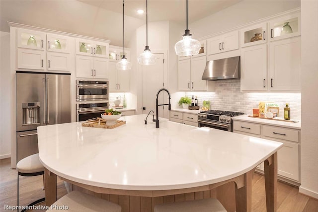 8413 Peach St, Justin, TX 76247 - kitchen featuring wall chimney range hood, high end appliances, a kitchen bar, and white cabinetry