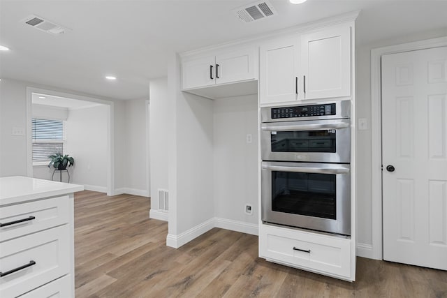 16030 Saint Paul Dr, Caney City, TX 75148 - kitchen featuring stainless steel double oven, baseboards, white cabinets, light wood-style floors, and recessed lighting