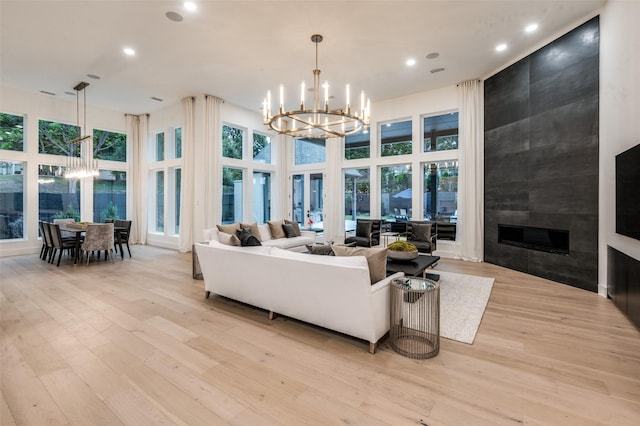 6075 Jordan Way, Frisco, TX 75034 - living area featuring a chandelier, light wood-style flooring, recessed lighting, plenty of natural light, and a tiled fireplace