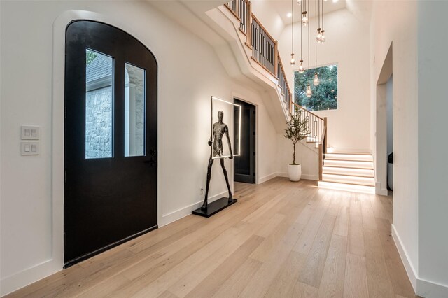 6075 Jordan Way, Frisco, TX 75034 - entryway featuring stairway, light wood-type flooring, arched walkways, baseboards, and a towering ceiling