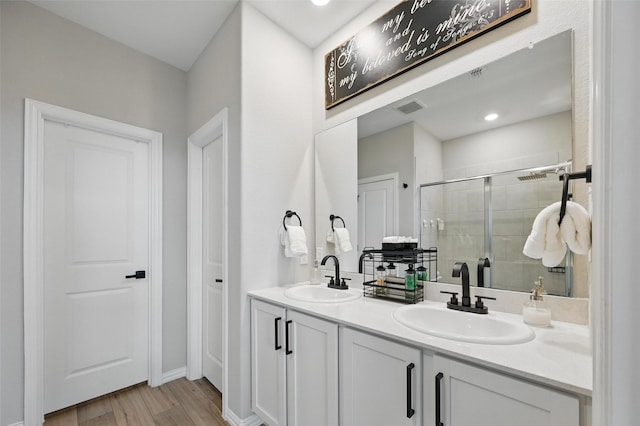 1229 Sequoia Ln, Princeton, TX 75407 - bathroom with double vanity, a shower stall, and wood finished floors