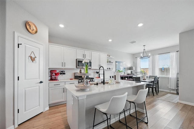 1229 Sequoia Ln, Princeton, TX 75407 - kitchen with stainless steel appliances, white cabinetry, light countertops, a kitchen island with sink, and recessed lighting
