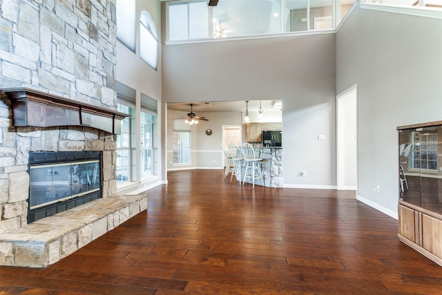 2206 Virginia Ln, Haslet, TX 76052 - unfurnished living room featuring ceiling fan, a high ceiling, healthy amount of natural light, hardwood / wood-style floors, and a fireplace