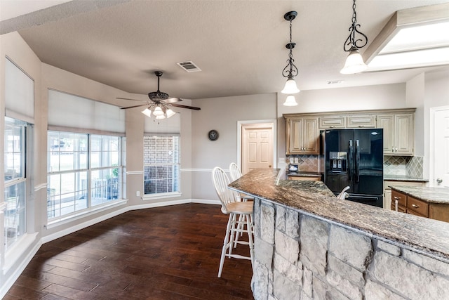 2206 Virginia Ln, Haslet, TX 76052 - kitchen with black fridge, stone countertops, dark wood-style flooring, decorative backsplash, and a textured ceiling