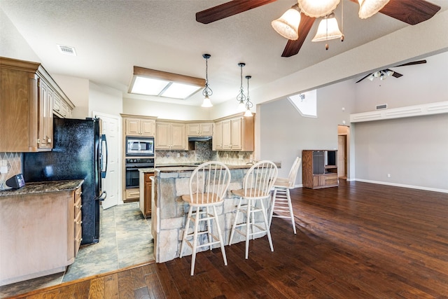 2206 Virginia Ln, Haslet, TX 76052 - kitchen featuring black appliances, ceiling fan, backsplash, dark wood-style flooring, and a kitchen breakfast bar
