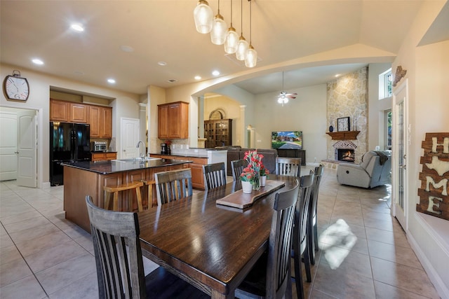 7811 Keith Ln, Sachse, TX 75048 - dining area featuring arched walkways, light tile patterned floors, ceiling fan, a fireplace, and recessed lighting