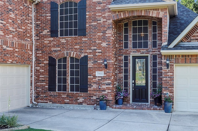 7811 Keith Ln, Sachse, TX 75048 - property entrance with concrete driveway, brick siding, and a shingled roof
