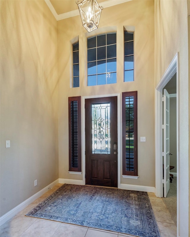 7811 Keith Ln, Sachse, TX 75048 - tiled entryway with a chandelier, crown molding, a high ceiling, and baseboards