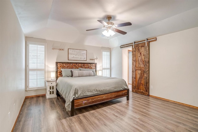 1103 Dirkson St, Weatherford, TX 76086 - bedroom featuring a barn door, wood finished floors, baseboards, vaulted ceiling, and ceiling fan