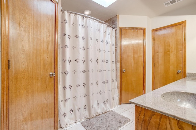 1103 Dirkson St, Weatherford, TX 76086 - full bathroom featuring double vanity, tile patterned flooring, a shower with curtain, and a skylight