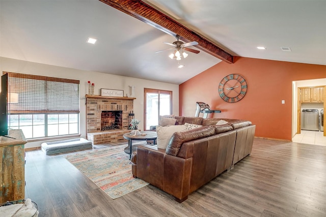 1103 Dirkson St, Weatherford, TX 76086 - living room featuring light wood finished floors, ceiling fan, a brick fireplace, and washer and clothes dryer