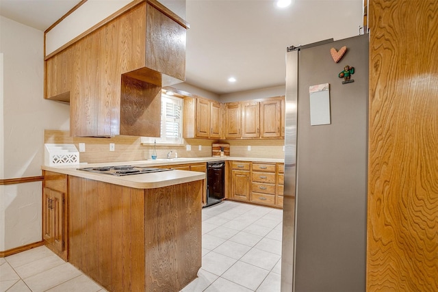 1103 Dirkson St, Weatherford, TX 76086 - kitchen with freestanding refrigerator, tasteful backsplash, a peninsula, light countertops, and light tile patterned flooring