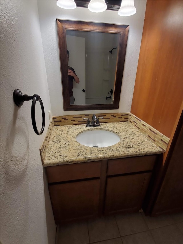 12480 Abrams Rd, Dallas, TX 75243 - bathroom featuring vanity, tile patterned flooring, a textured wall, and a shower
