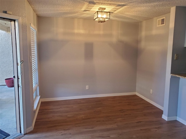 12480 Abrams Rd, Dallas, TX 75243 - unfurnished dining area with wood finished floors, a textured ceiling, and baseboards