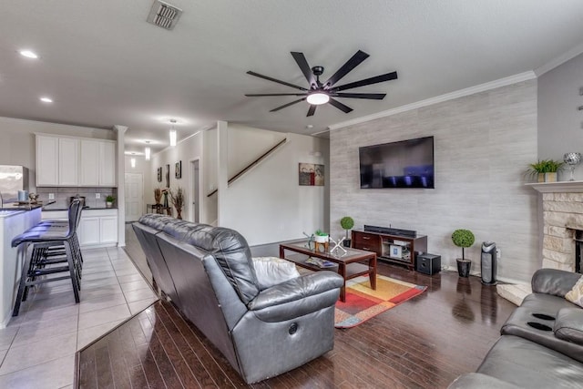 7828 Tudanca Trl, Fort Worth, TX 76131 - living area featuring a ceiling fan, an accent wall, a fireplace, crown molding, and recessed lighting
