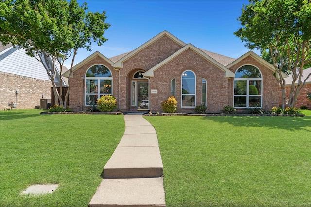 11505 Canoe Rd, Frisco, TX 75035 - view of front of house featuring a front yard, brick siding, and central air condition unit