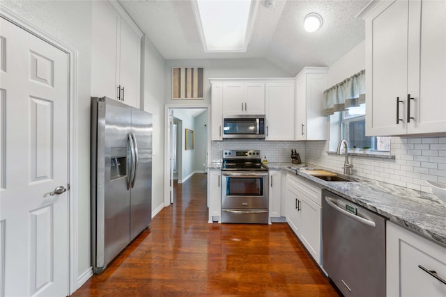 11505 Canoe Rd, Frisco, TX 75035 - kitchen featuring stainless steel appliances, a sink, backsplash, lofted ceiling, and light stone countertops