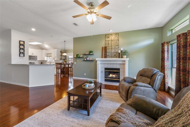 11505 Canoe Rd, Frisco, TX 75035 - living room with wood finished floors, ceiling fan, baseboards, a textured ceiling, and a fireplace