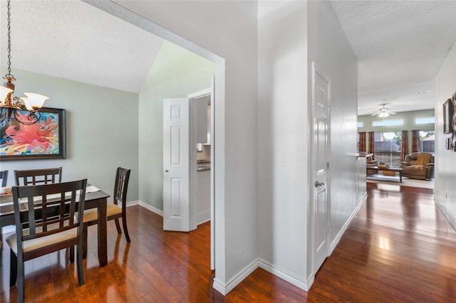 11505 Canoe Rd, Frisco, TX 75035 - corridor with a chandelier, dark wood-style flooring, baseboards, a textured ceiling, and vaulted ceiling