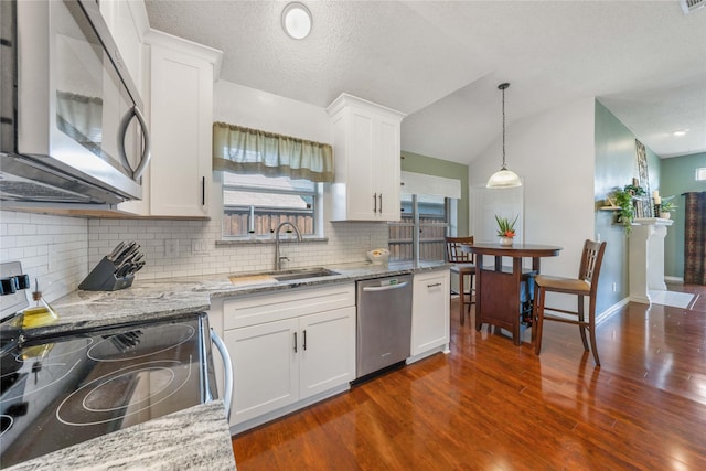 11505 Canoe Rd, Frisco, TX 75035 - kitchen featuring stainless steel appliances, a sink, white cabinets, tasteful backsplash, and light stone countertops