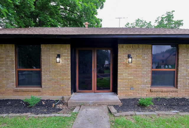 6519 Club Wood, Dallas, TX 75237 - view of exterior entry with french doors, brick siding, and roof with shingles