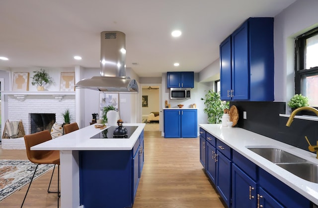 6519 Club Wood, Dallas, TX 75237 - kitchen with island range hood, blue cabinetry, a sink, stainless steel microwave, and recessed lighting