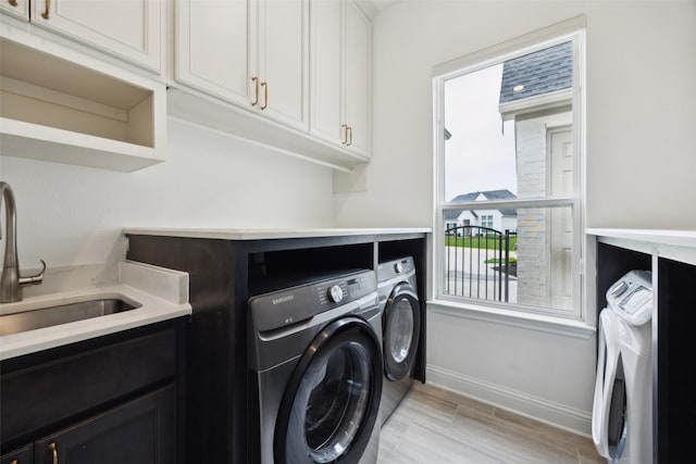 3705 Melville Cir, Flower Mound, TX 75022 - washroom with washer and clothes dryer, cabinet space, baseboards, and light wood finished floors
