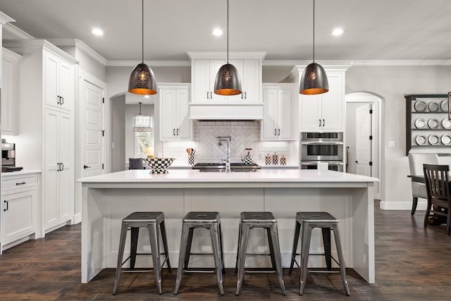 116 Estancia Ct, Decatur, TX 76234 - kitchen with arched walkways, recessed lighting, decorative backsplash, stainless steel double oven, and crown molding