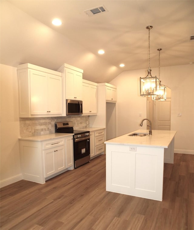 705 Raylan St, Springtown, TX 76082 - kitchen with appliances with stainless steel finishes, a sink, lofted ceiling, white cabinets, and tasteful backsplash