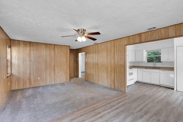 118 Dogwood Trl, Gun Barrel City, TX 75156 - unfurnished living room featuring a sink, ceiling fan, wooden walls, a textured ceiling, and light wood finished floors
