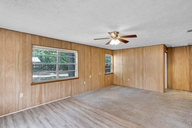 118 Dogwood Trl, Gun Barrel City, TX 75156 - spare room with ceiling fan, plenty of natural light, wooden walls, a textured ceiling, and wood finished floors