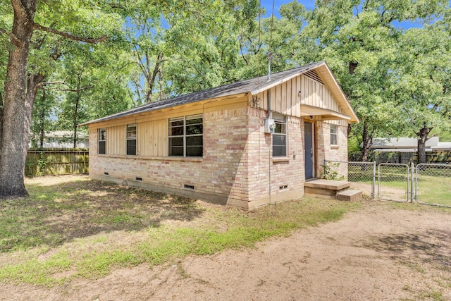 118 Dogwood Trl, Gun Barrel City, TX 75156 - view of home's exterior with crawl space, brick siding, a gate, and board and batten siding