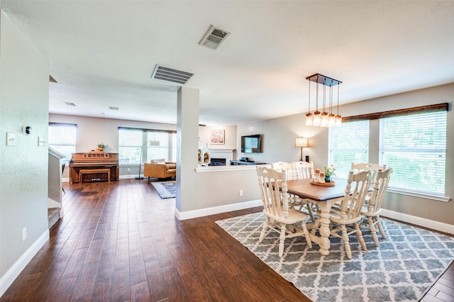 1405 Cardinal Way, Aubrey, TX 76227 - dining room with baseboards, dark wood-type flooring, and a fireplace