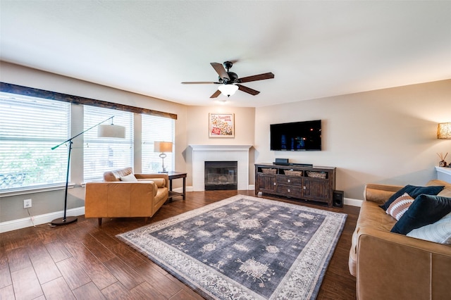 1405 Cardinal Way, Aubrey, TX 76227 - living area featuring a ceiling fan, baseboards, a glass covered fireplace, and dark wood-type flooring