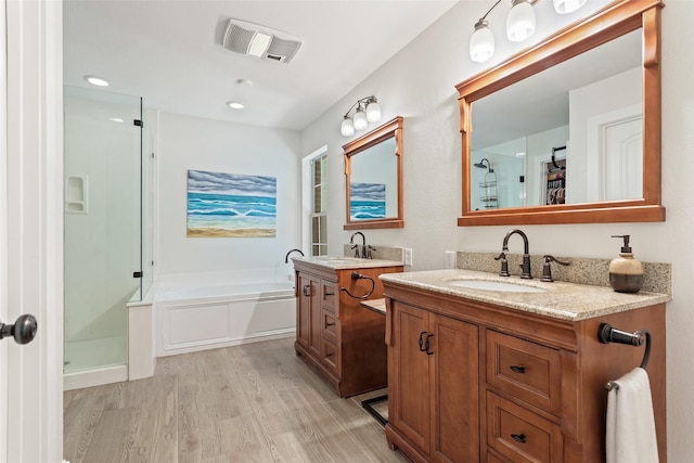10443 County Road 3407, Brownsboro, TX 75756 - full bathroom featuring wood finished floors, a stall shower, a bath, and two vanities