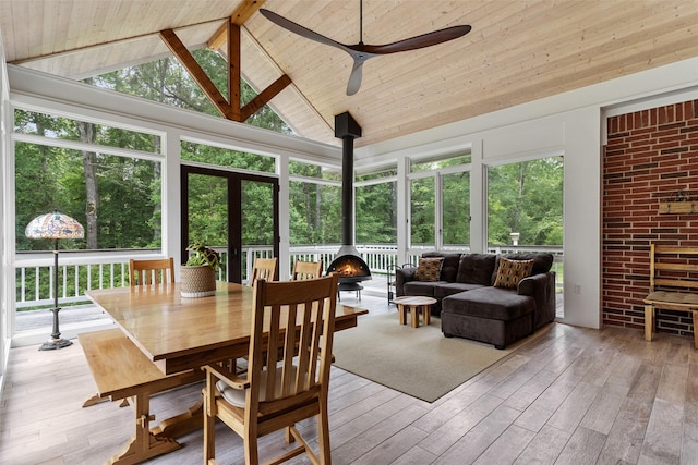 10443 County Road 3407, Brownsboro, TX 75756 - sunroom with a wood stove, a deck, wood-type flooring, high vaulted ceiling, and plenty of natural light