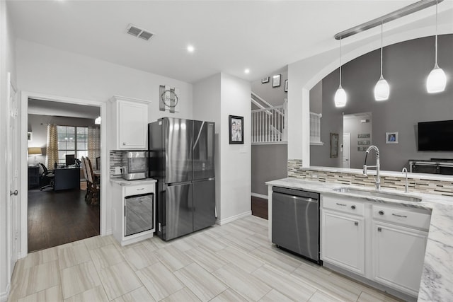 7113 Sundance Ln, Fort Worth, TX 76179 - kitchen with stainless steel appliances, a sink, backsplash, white cabinetry, and recessed lighting