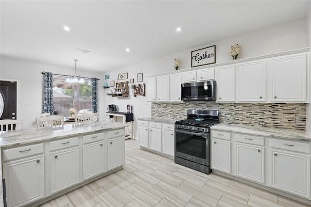 7113 Sundance Ln, Fort Worth, TX 76179 - kitchen with stainless steel appliances, backsplash, white cabinetry, a chandelier, and pendant lighting