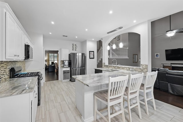 7113 Sundance Ln, Fort Worth, TX 76179 - kitchen with stainless steel appliances, a sink, decorative backsplash, light stone counters, and a breakfast bar