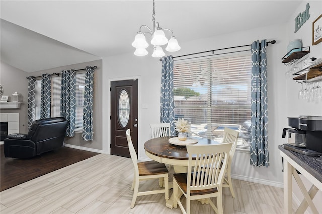 7113 Sundance Ln, Fort Worth, TX 76179 - dining room featuring a chandelier, baseboards, light wood-style flooring, and a fireplace