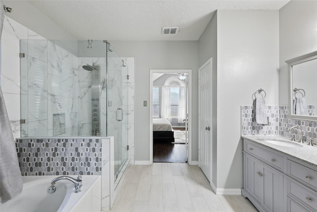 7113 Sundance Ln, Fort Worth, TX 76179 - bathroom with a marble finish shower, a bath, vanity, a textured ceiling, and tasteful backsplash