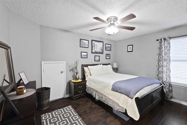 7113 Sundance Ln, Fort Worth, TX 76179 - bedroom with multiple windows, dark wood-style floors, a textured ceiling, baseboards, and a ceiling fan