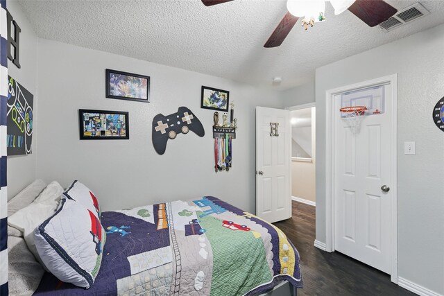 7113 Sundance Ln, Fort Worth, TX 76179 - bedroom with dark wood finished floors, a textured ceiling, a ceiling fan, and baseboards
