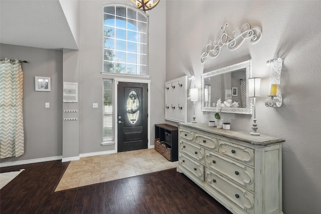 7113 Sundance Ln, Fort Worth, TX 76179 - foyer with wood finished floors, a towering ceiling, and baseboards