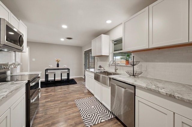 14053 Stardust Ln, Farmers Branch, TX 75234 - kitchen featuring stainless steel appliances, a sink, tasteful backsplash, recessed lighting, and white cabinetry