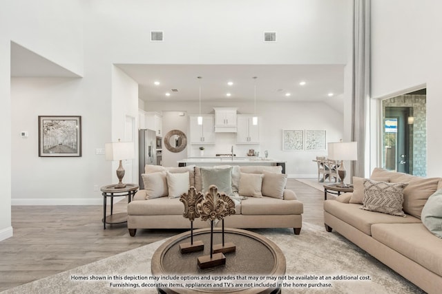 12709 Cactus Ct, Godley, TX 76044 - living room featuring light wood-style floors, a towering ceiling, recessed lighting, and baseboards