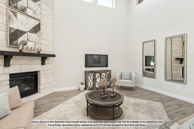 12709 Cactus Ct, Godley, TX 76044 - living room with a towering ceiling, baseboards, wood finished floors, and a fireplace