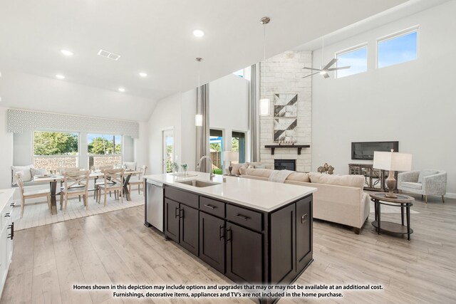 12709 Cactus Ct, Godley, TX 76044 - kitchen with a sink, dishwasher, light wood-type flooring, a fireplace, and high vaulted ceiling