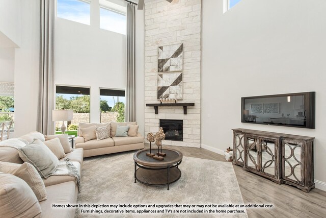 12709 Cactus Ct, Godley, TX 76044 - living area featuring a towering ceiling, a fireplace, wood finished floors, and baseboards